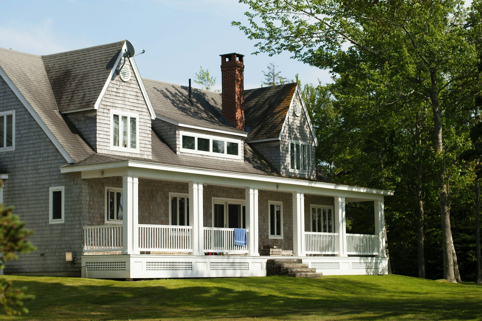white and brown wooden house near green trees during daytime, homeowners